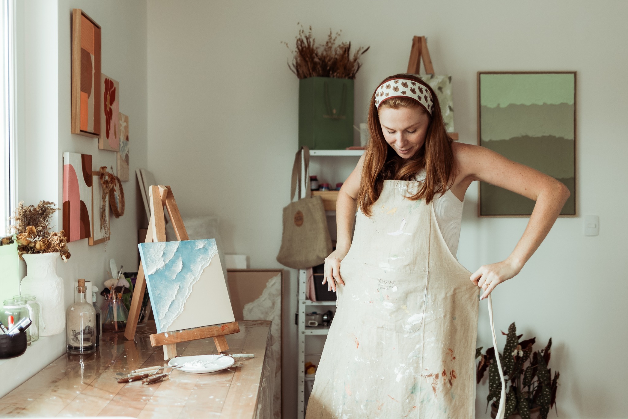 Jeniffer Borchardt de avental no ateliê Bohoart